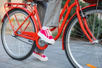 Photo of Teenage girl riding bicycle on city street, closeup
