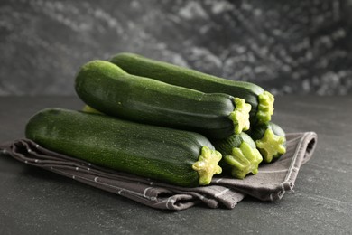 Photo of Fresh ripe zucchinis on black table, closeup