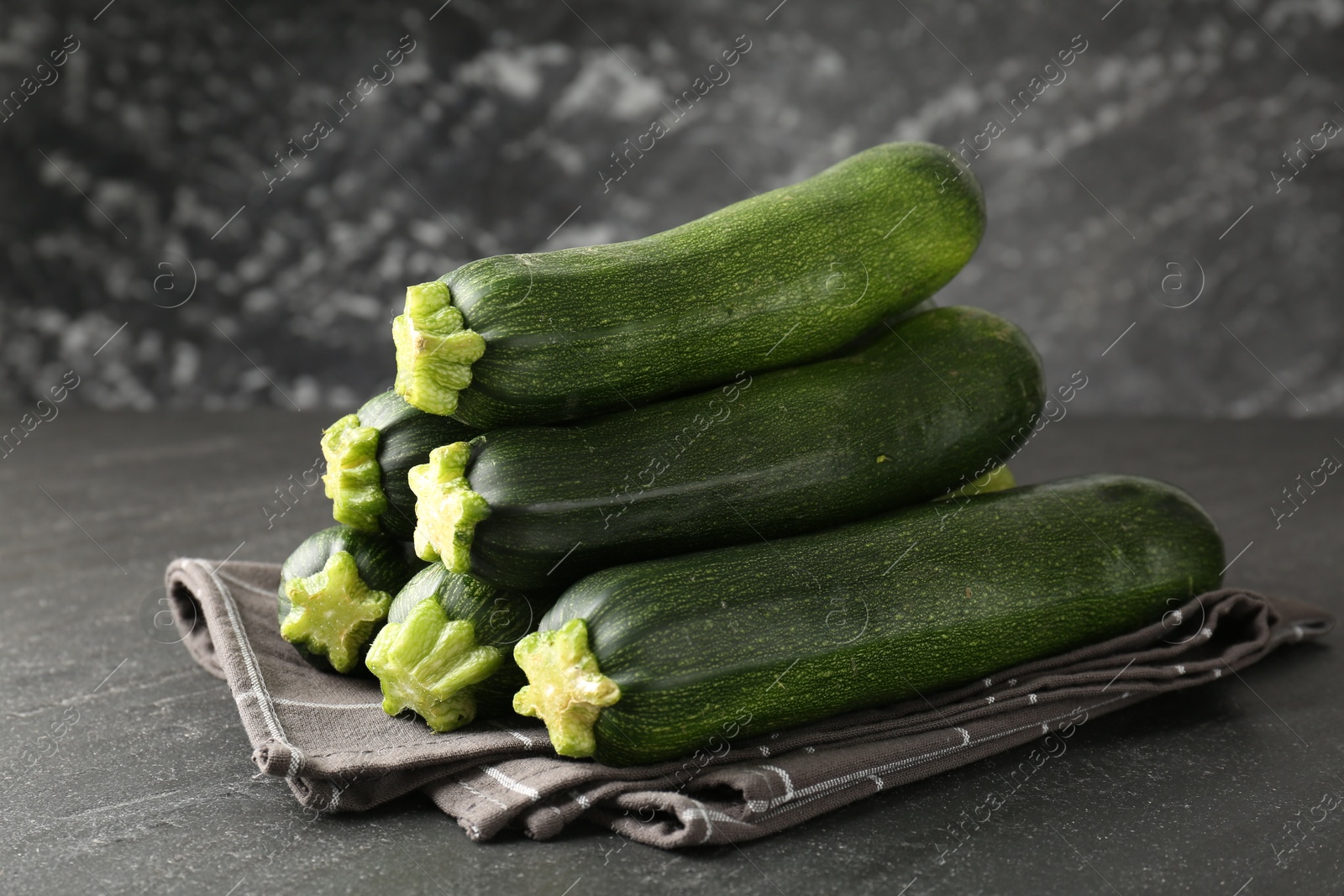Fresh ripe zucchinis on black table, closeup Photo of Fresh ripe zucchinis on black table, closeup