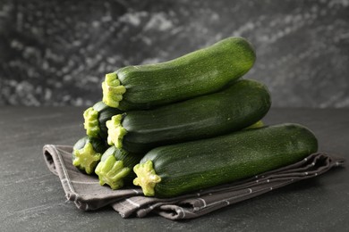 Photo of Fresh ripe zucchinis on black table, closeup