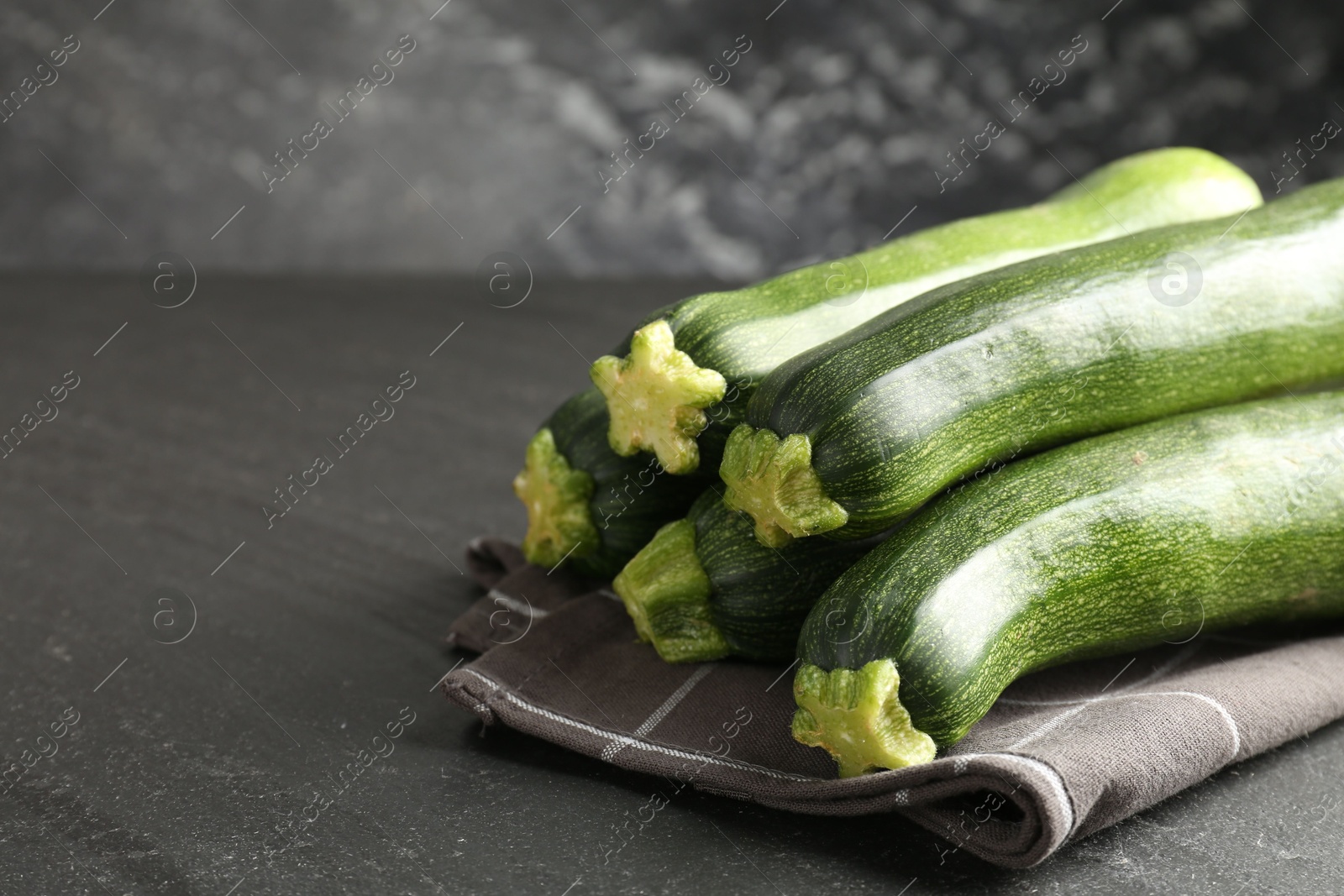 Fresh ripe zucchinis on black table, closeup. Space for text Photo of Fresh ripe zucchinis on black table, closeup. Space for text