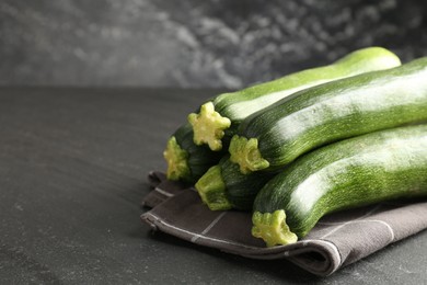 Photo of Fresh ripe zucchinis on black table, closeup. Space for text