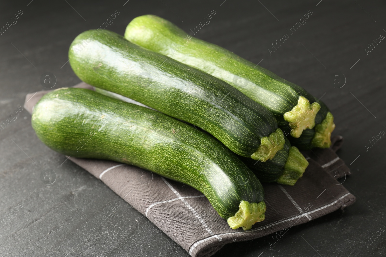 Fresh ripe zucchinis on black table, closeup Photo of Fresh ripe zucchinis on black table, closeup