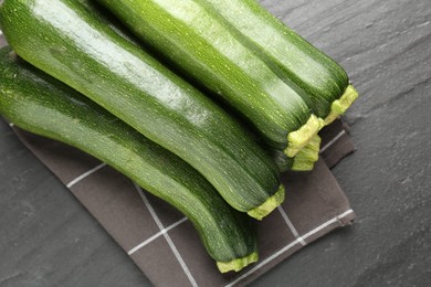 Photo of Fresh ripe zucchinis on black table, top view