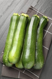 Photo of Fresh ripe zucchinis on black table, top view
