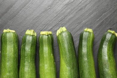 Photo of Fresh ripe zucchinis on black table, flat lay
