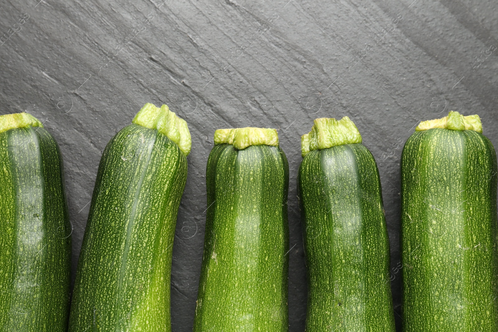 Fresh ripe zucchinis on black table, flat lay Photo of Fresh ripe zucchinis on black table, flat lay
