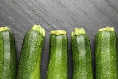 Photo of Fresh ripe zucchinis on black table, flat lay