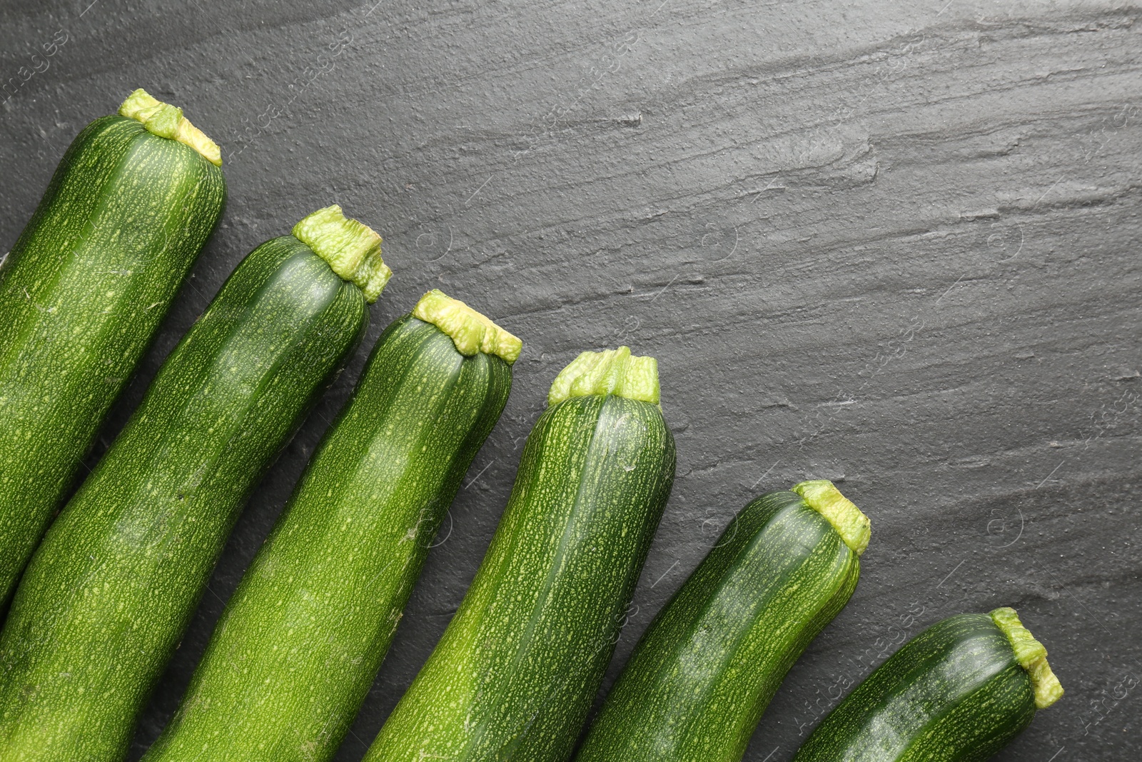 Fresh ripe zucchinis on black table, flat lay Photo of Fresh ripe zucchinis on black table, flat lay