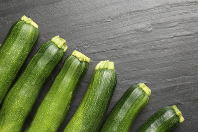 Photo of Fresh ripe zucchinis on black table, flat lay
