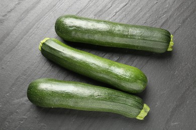 Photo of Fresh ripe zucchinis on black table, flat lay