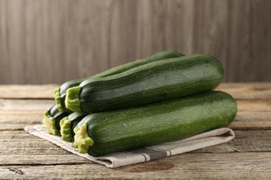 Photo of Fresh ripe zucchinis on wooden table, closeup
