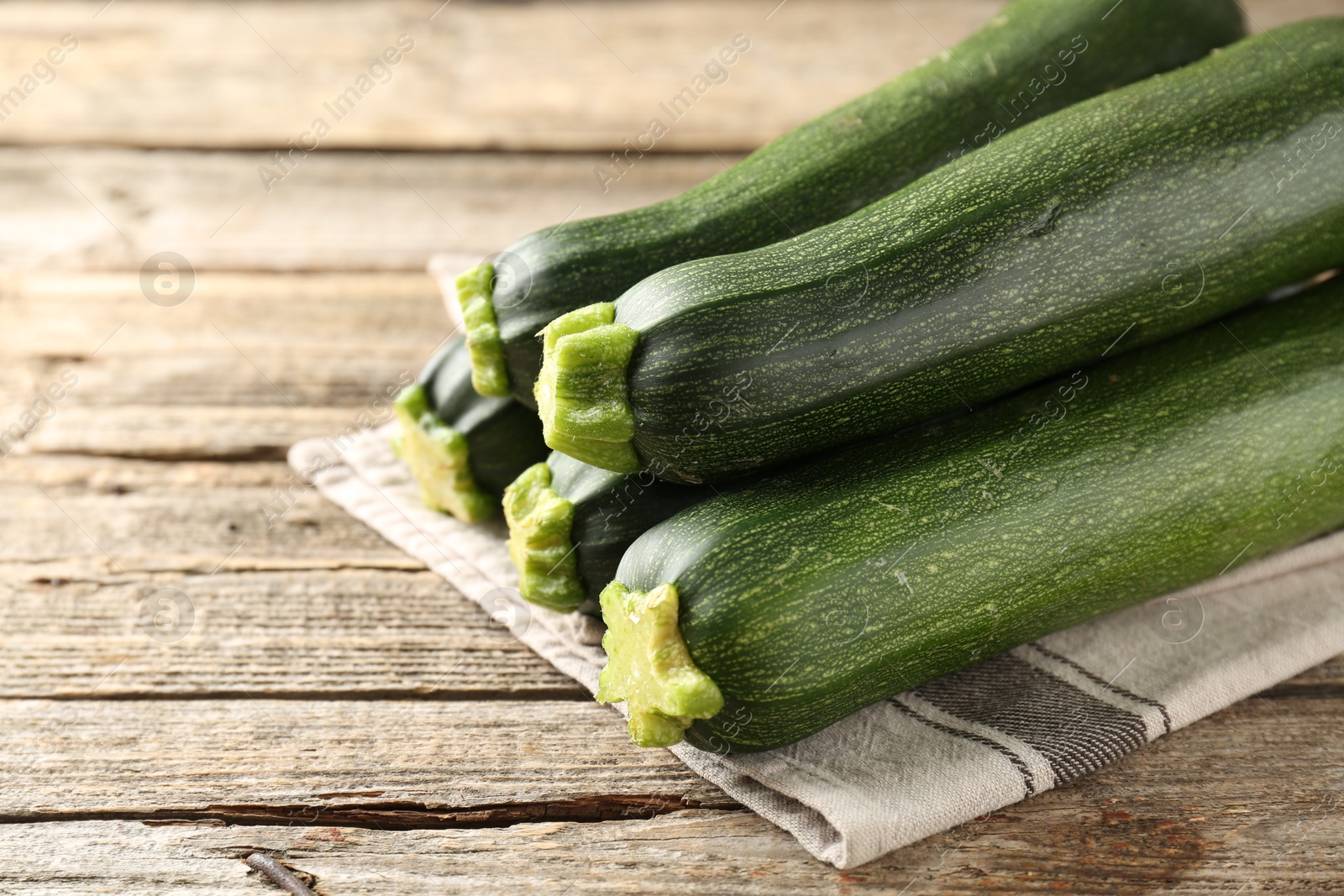 Fresh ripe zucchinis on wooden table, closeup. Space for text Photo of Fresh ripe zucchinis on wooden table, closeup. Space for text