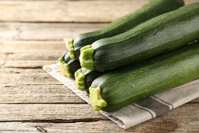 Photo of Fresh ripe zucchinis on wooden table, closeup. Space for text