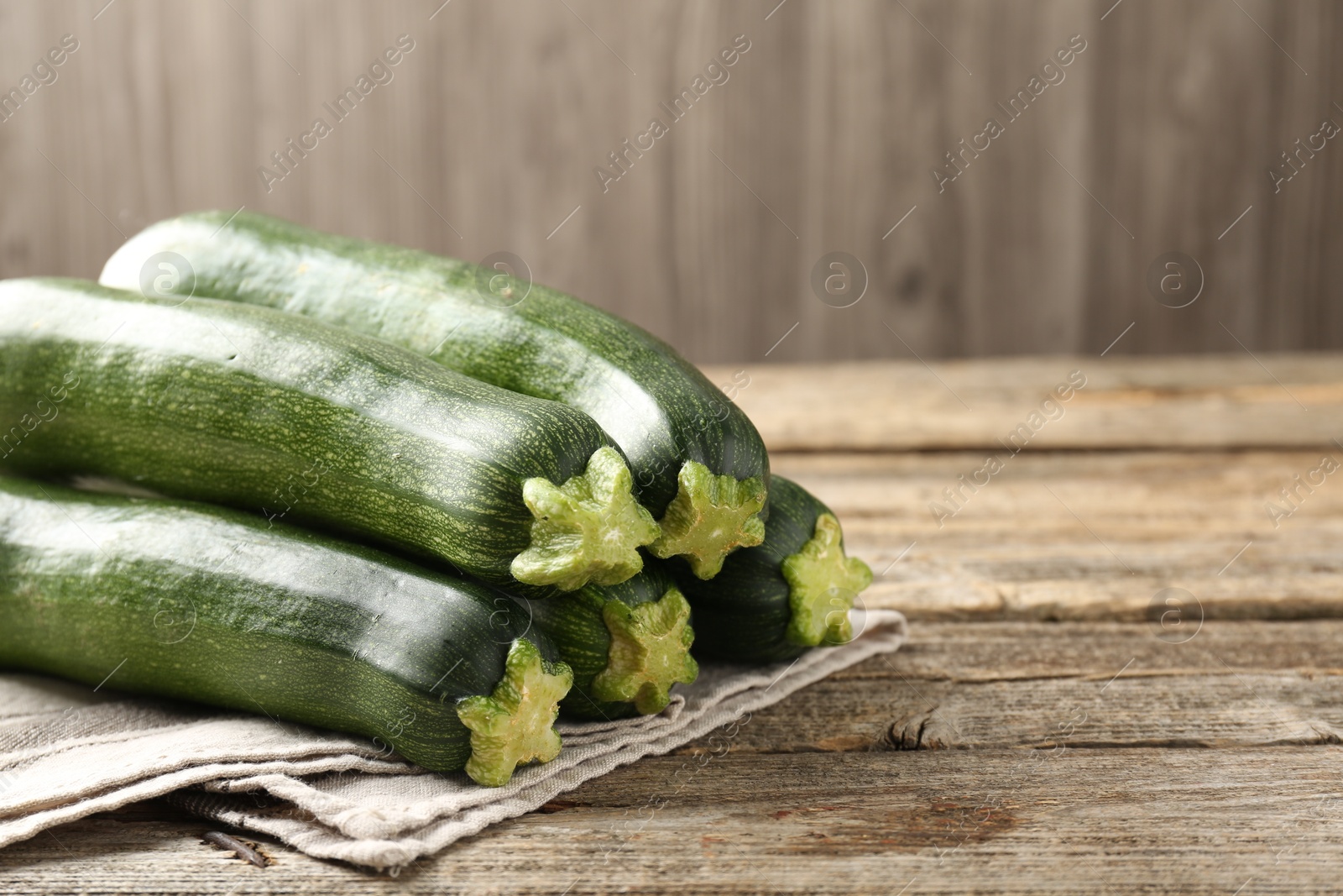 Fresh ripe zucchinis on wooden table, closeup. Space for text Photo of Fresh ripe zucchinis on wooden table, closeup. Space for text
