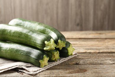 Photo of Fresh ripe zucchinis on wooden table, closeup. Space for text