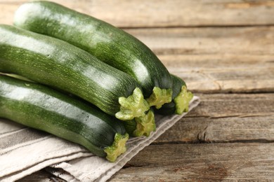 Photo of Fresh ripe zucchinis on wooden table, closeup. Space for text
