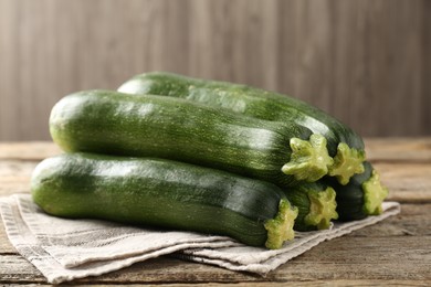 Photo of Fresh ripe zucchinis on wooden table, closeup