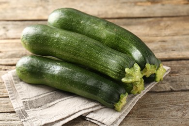 Photo of Fresh ripe zucchinis on wooden table, closeup