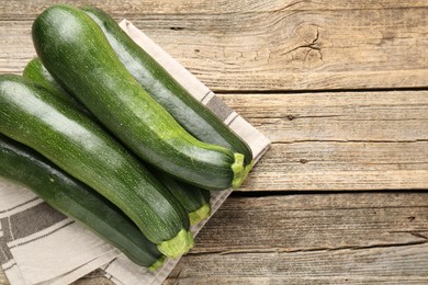 Photo of Fresh ripe zucchinis on wooden table, top view. Space for text