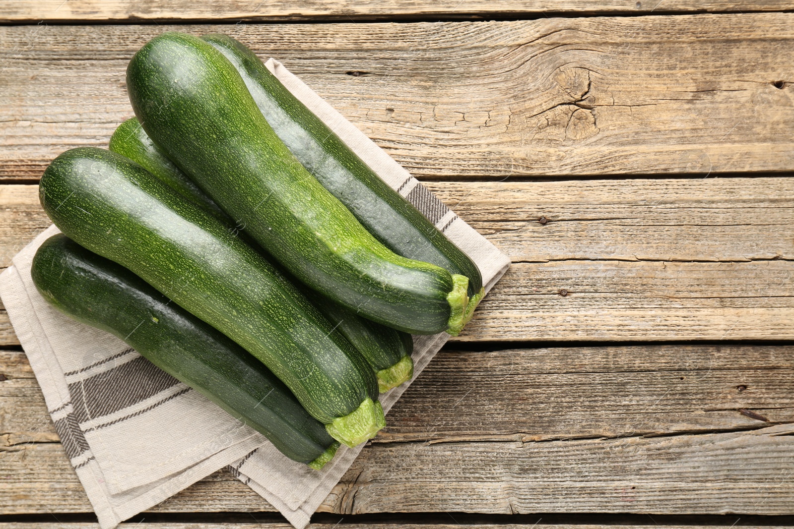 Fresh ripe zucchinis on wooden table, top view. Space for text Photo of Fresh ripe zucchinis on wooden table, top view. Space for text