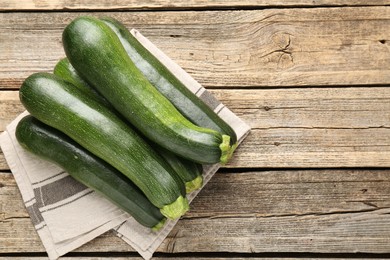Photo of Fresh ripe zucchinis on wooden table, top view. Space for text