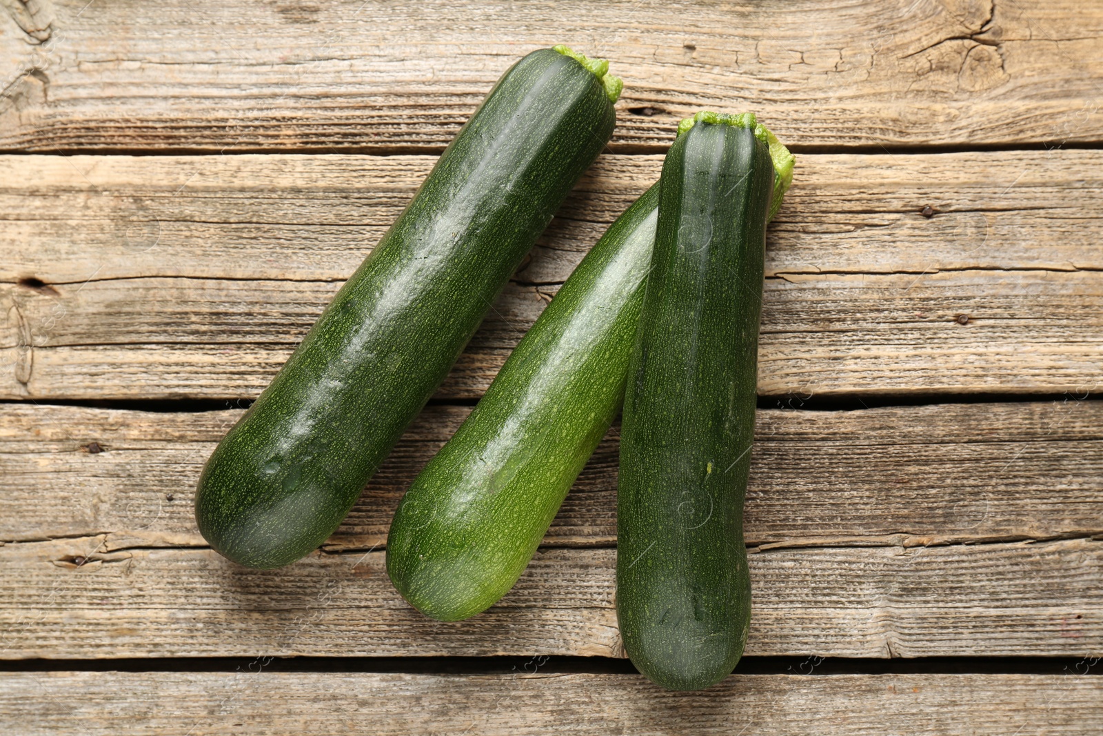 Fresh ripe zucchinis on wooden table, flat lay Photo of Fresh ripe zucchinis on wooden table, flat lay