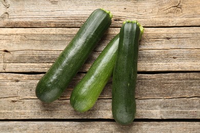 Photo of Fresh ripe zucchinis on wooden table, flat lay