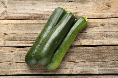 Photo of Fresh ripe zucchinis on wooden table, flat lay