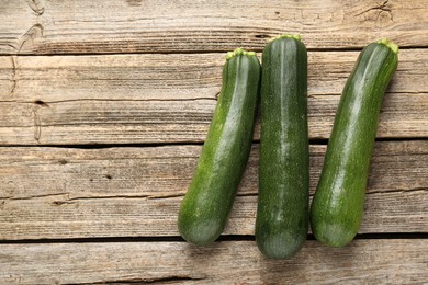 Photo of Fresh ripe zucchinis on wooden table, flat lay. Space for text