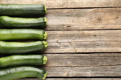 Photo of Fresh ripe zucchinis on wooden table, flat lay. Space for text