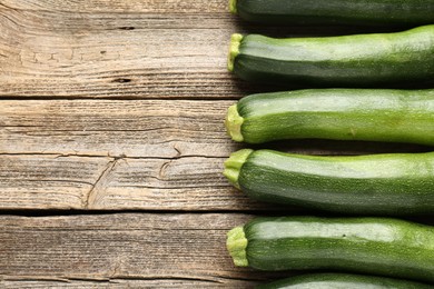 Photo of Fresh ripe zucchinis on wooden table, flat lay. Space for text