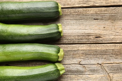 Photo of Fresh ripe zucchinis on wooden table, flat lay. Space for text