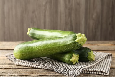 Photo of Fresh ripe zucchinis on wooden table, closeup