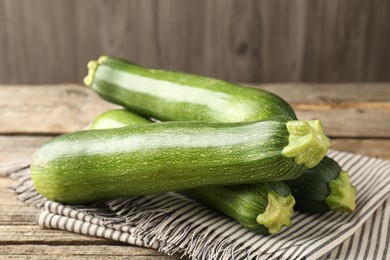 Photo of Fresh ripe zucchinis on wooden table, closeup