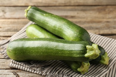 Photo of Fresh ripe zucchinis on wooden table, closeup