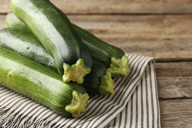 Photo of Fresh ripe zucchinis on wooden table, closeup. Space for text