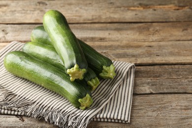 Photo of Fresh ripe zucchinis on wooden table, closeup. Space for text