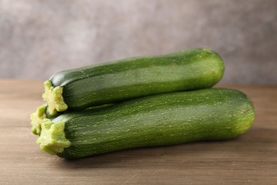 Photo of Fresh ripe zucchinis on wooden table, closeup