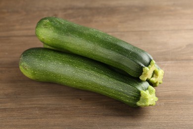 Photo of Fresh ripe zucchinis on wooden table, closeup