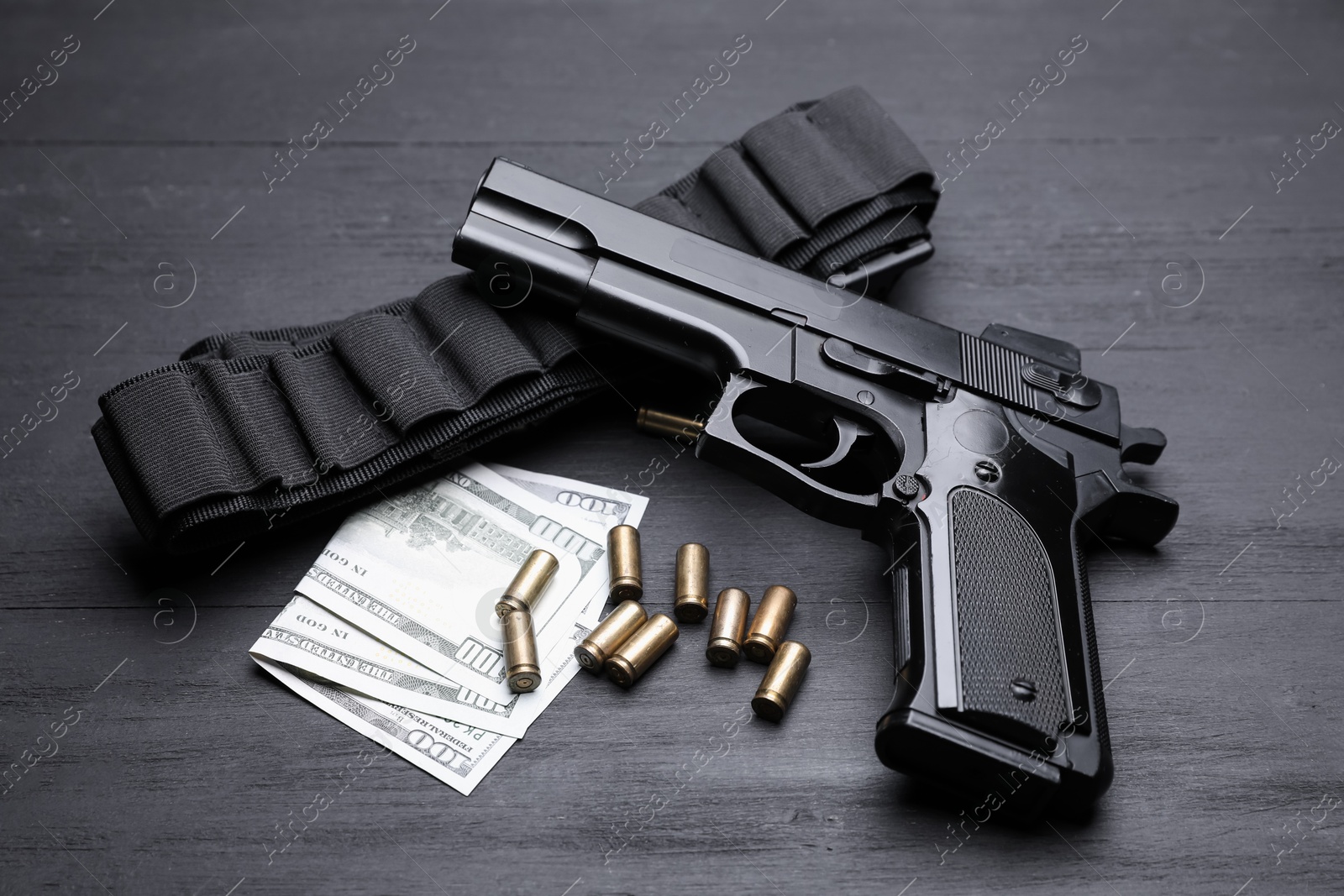 Gun, cartridges and dollar banknotes on black background Photo of Gun, cartridges and dollar banknotes on black background