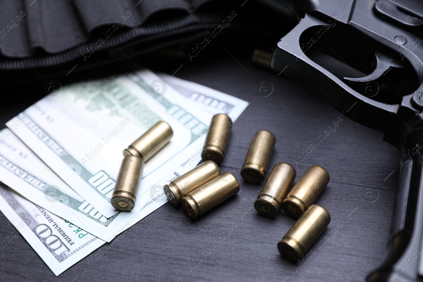 Gun, cartridges and dollar banknotes on black background, closeup Photo of Gun, cartridges and dollar banknotes on black background, closeup
