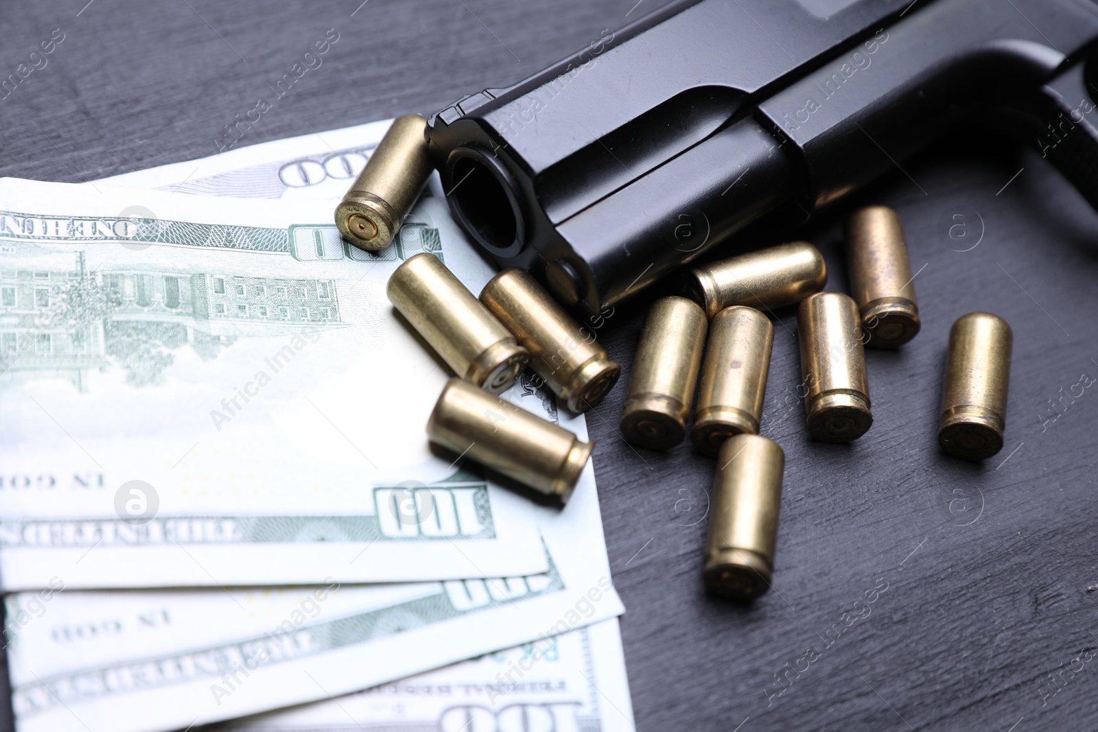 Gun, cartridges and dollar banknotes on black background, closeup Photo of Gun, cartridges and dollar banknotes on black background, closeup