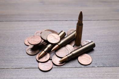 Photo of Firearm cartridges and coins on wooden table