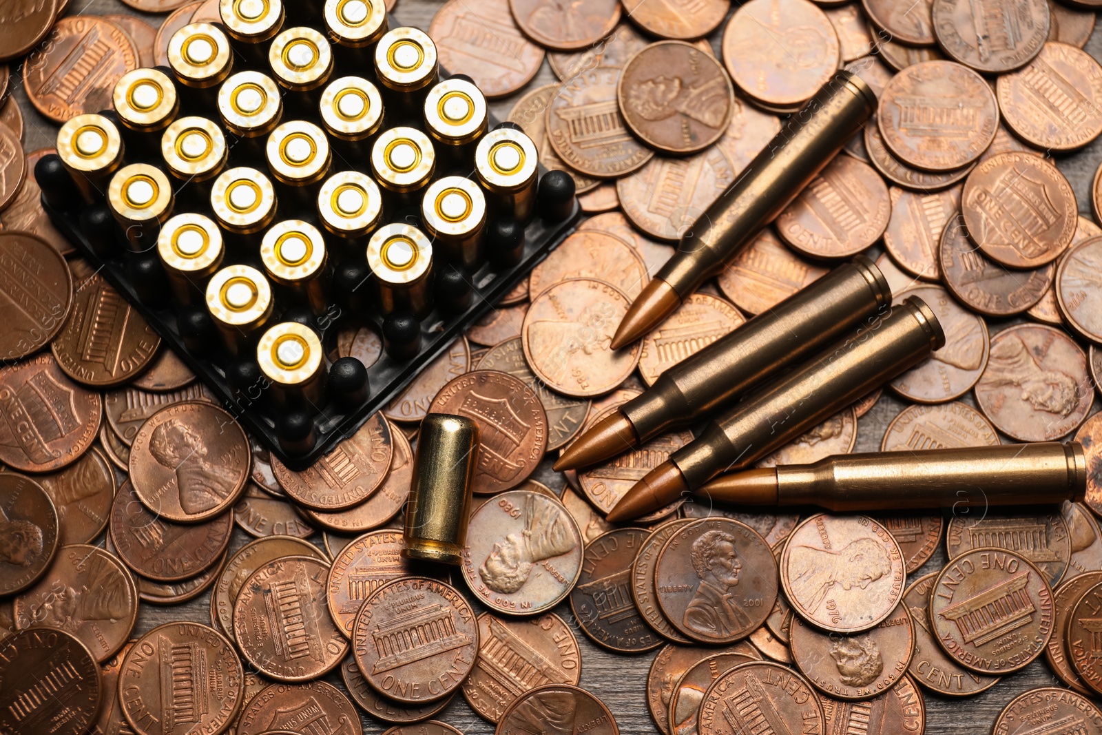 Many firearm cartridges on coins, top view Photo of Many firearm cartridges on coins, top view