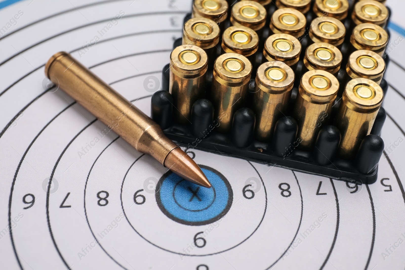 Firearm cartridges on paper target, closeup view Photo of Firearm cartridges on paper target, closeup view
