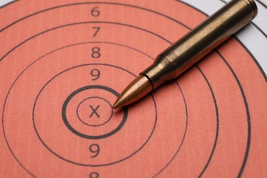 Photo of Firearm cartridge on paper target, closeup view
