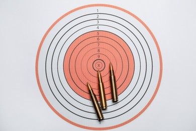 Photo of Firearm cartridges on paper target, flat lay