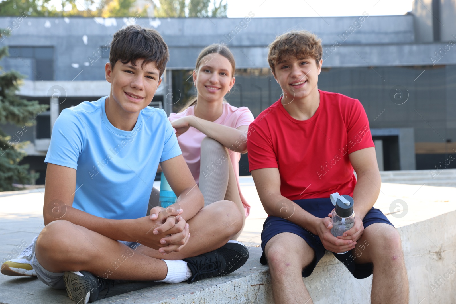 Group of teenagers resting after training outdoors Photo of Group of teenagers resting after training outdoors