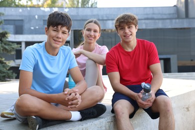 Photo of Group of teenagers resting after training outdoors